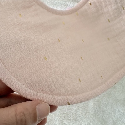 babete rosa claro com pequenos pontinhos dourados em tecido macio