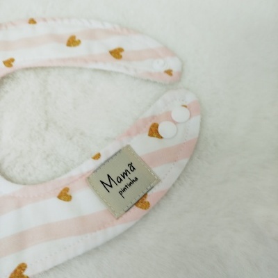 Babete rosa com corações amarelos e etiqueta 