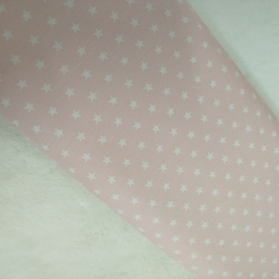 Tecido rosa claro com estrelas brancas sobre fundo branco felpudo