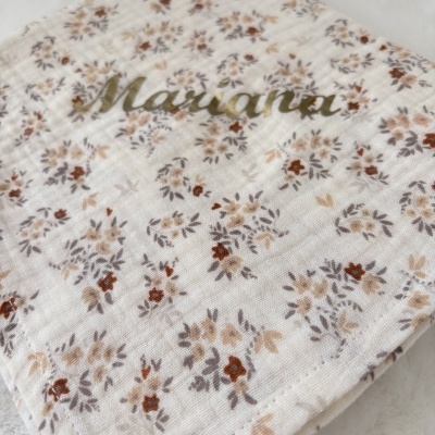 Capa de tecido floral com nome Mariana em letras douradas