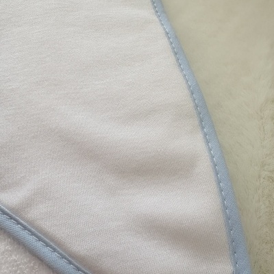 Tecido branco com acabamento azul claro e superfície macia bege