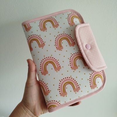 Carteira ou estojo com padrão de arcos-íris e fecho rosa com botão