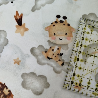 tecido branco com padrão de nuvens estrelas e girafa caricaturada e régua transparente