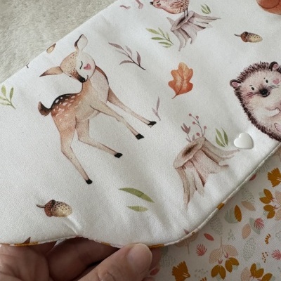 tecido branco com padrão de animais da floresta e folhas em cores suaves