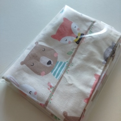 Tecido branco com estampado de animais coloridos embalado em plástico