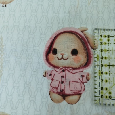 Tecido com estampa de coelho em casaco rosa e régua ao lado