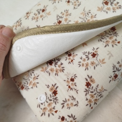 Capa de almofada com padrão floral, acabamento dourado e fecho de encaixe