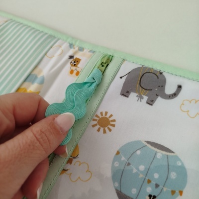 Produto têxtil para bebé com estampados de balão, elefante, sol e coelho em cores suaves