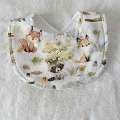 Babete de bebé branco com padrão de animais da floresta