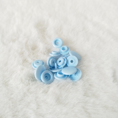 Botões de pressão de plástico azul claro em superfície felpuda branca