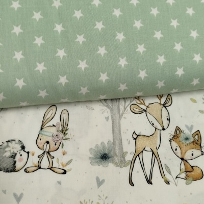Tecidos infantis, um com estrelas brancas em fundo verde-menta e outro com animais desenhados sobre fundo claro