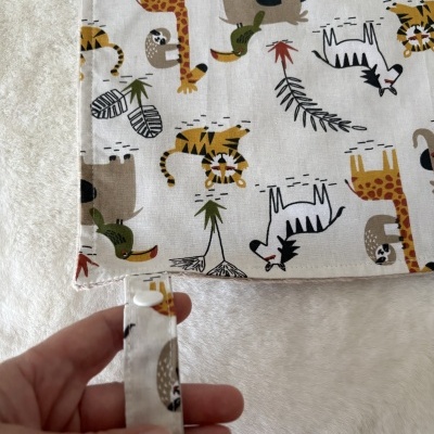 Tecido branco com padrão de animais e alça com fecho branco