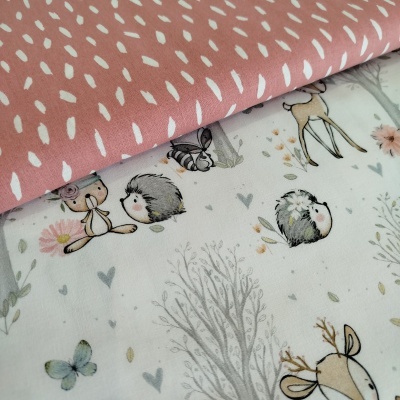 Tecidos infantis com estampas de animais e padrões em tons suaves