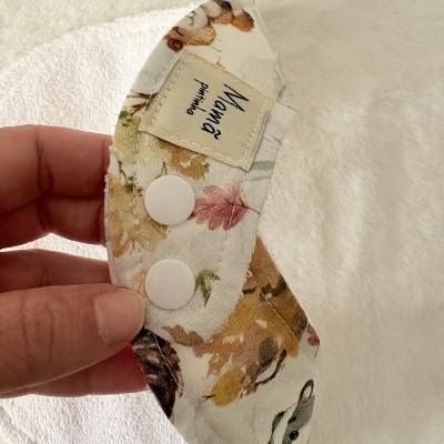 Babete em tecido de felpo branco com parte superior estampada e botões de pressão brancos