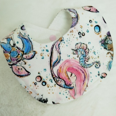 Babete com padrão de criaturas marinhas coloridas e fundo branco