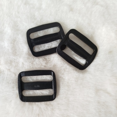 Três fivelas de plástico preto sobre superfície branca