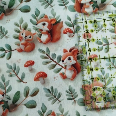 Tecido branco com padrão de esquilos, cogumelos e folhas, com régua transparente em cima