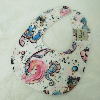 Babete com padrão de sereias coloridas e fecho rosa