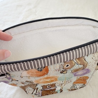 Bolsa estampada a abrir com fecho de correr e riscas na bainha.
