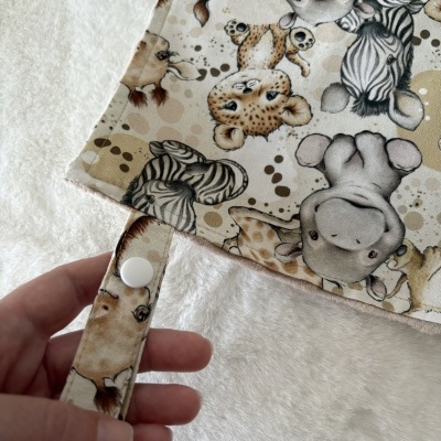 tecido estampado com animais e mola branca em fundo peludo branco
