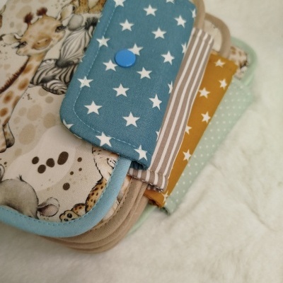 Fraldas de pano coloridas com diferentes padrões e acabamentos em tecido macio.