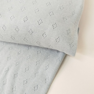 Tecido azul claro com padrão de losangos perfurados