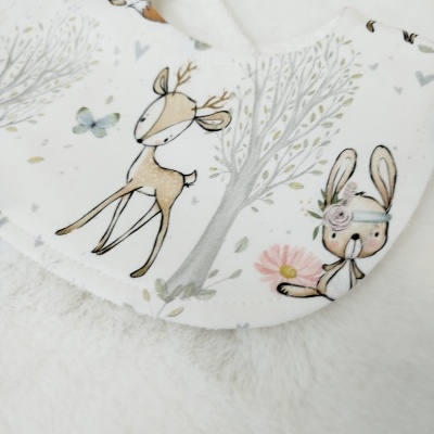 Babete de tecido branco com desenhos de veado, lebre e árvore