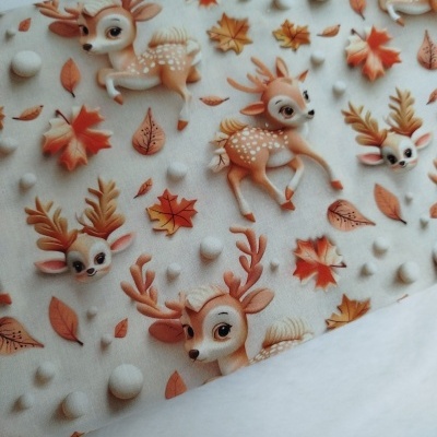 Tecido estampado com desenhos de veados e folhas em cores outonais