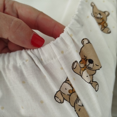 tecido branco com padrão de ursos castanhos abraçando ursinhos pequenos e bainha elástica