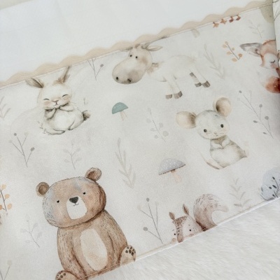Tecido para bebé com padrão de desenhos de animais e plantas em tons suaves sobre superfície branca