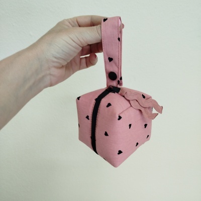 Saco de tecido rosa com corações pretos e alça para pendurar