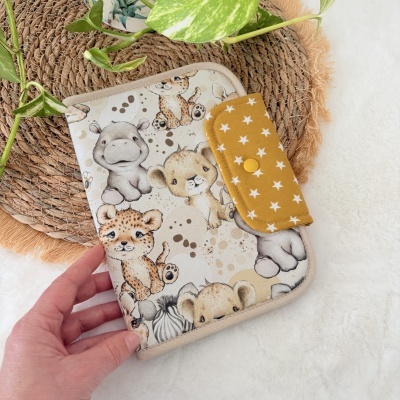 Capa infantil com padrão de animais e fecho amarelo com estrelas