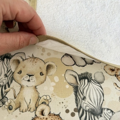 Tecido com estampado de animais bebês em tons neutros e parte superior branca felpuda