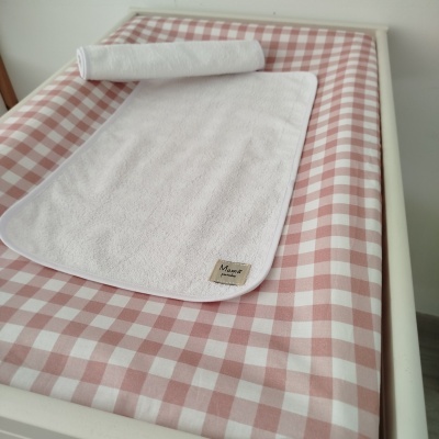 Toalha branca sobre capa xadrez rosa e branco com etiqueta Mamá pininha