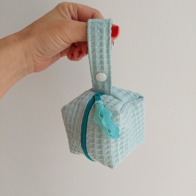 Bolsa pequena azul-claro em tecido com padrão xadrez, fecho de correr e alça com botão