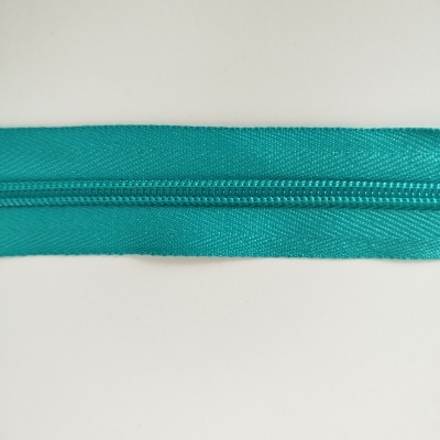 Fecho éclair verde água com textura brilhante sobre fundo branco.