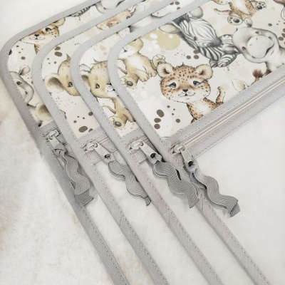 Capas protetoras para carrinho com padrão de animais e fechos cinzentos.