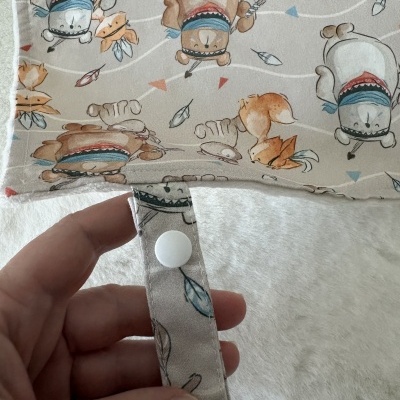 Tecido com padrão de desenhos de ursos e raposas e botões brancos