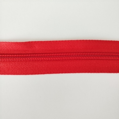 Fecho éclair vermelho com tecido sintético em fundo branco