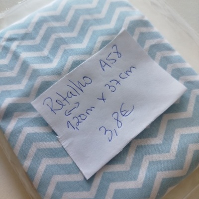 Tecido azul claro com padrão de ondas em zigzag branco embalado em plástico