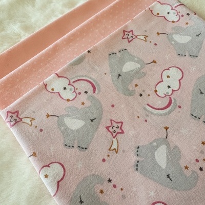 Tecidos rosa com diferentes padrões e felpudo branco ao fundo.