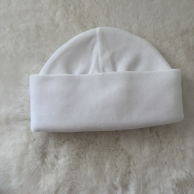 Gorro branco de tecido macio sobre superfície felpuda cinza claro