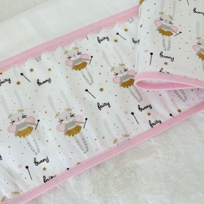 Manta infantil branca com padrão de coelhinhos de fada, borda rosa e fundo branco macio