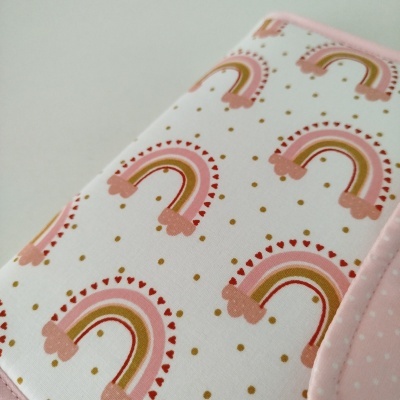 Capa de tecido branco com padrão de arcos-íris rosa e dourado com borda rosa
