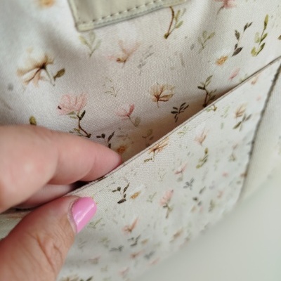 Bolsa de tecido bege com padrão floral e etiqueta Mamã pintinho