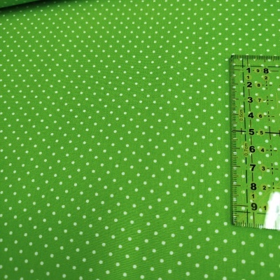 Tecido verde com pontos brancos e régua transparente em centímetros