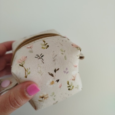 Estojo pequeno em tecido bege com flores coloridas e fecho castanho