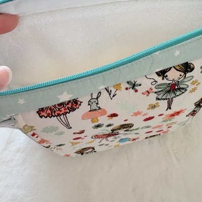 Bolsa com estampado de fadas, cogumelos e flores, bordas azul-turquesa e interior branco macio