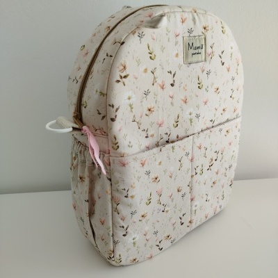 Mochila de pano com padrão floral em tons pastel e fecho zip