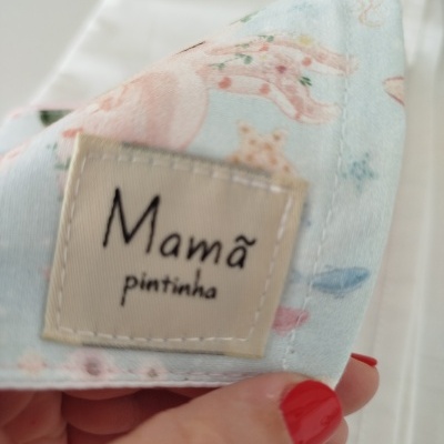 Máscara de tecido com padrão de animais e etiqueta com texto Mamã pintinha